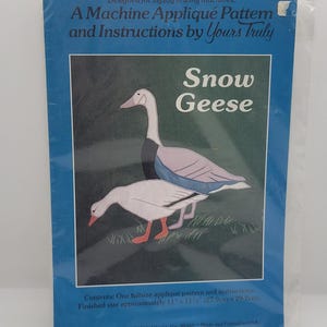 May include: A machine appliqué pattern and instructions by Yours Truly, featuring a design of two snow geese. The package is blue and includes the text "Snow Geese". Finished size is approximately 11" x 11 1/2".