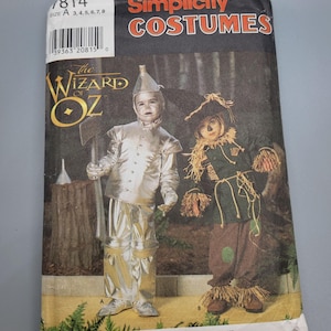 May include: Simplicity Costumes pattern featuring The Wizard of Oz. The cover shows two children in costume: one as the Tin Man in silver, and the other as the Scarecrow in brown and green. The pattern size is A 3,4,5,6,7,8.
