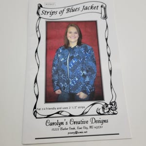 May include: A white paper with the title "Strips of Blues Jacket" and a photo of a woman wearing a blue patterned jacket. The text reads "Fat 1/4 Friendly and uses 2 1/2" strips" and "Carolyn's Creative Designs".