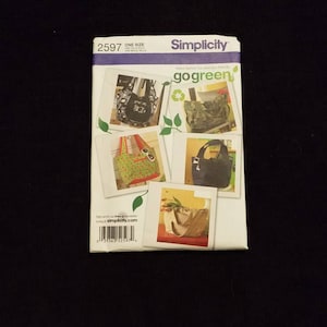 May include: Simplicity sewing pattern number 2597, one size, for making a tote bag. The pattern includes five different bag designs, with a green, white, and black color scheme. The pattern is titled "go green" and features a green leaf design.