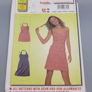 May include: A Burda Young Fashion sewing pattern packet, featuring a woman in a pink dress. The packet includes illustrations of two dress designs, size information, and the number 8613. The packet also has the text "All patterns with seam and hem allowances."