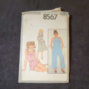 May include: A vintage Simplicity sewing pattern for a jumpsuit, dress, and shorts. The pattern number is 8567 and the size is 10 miss.