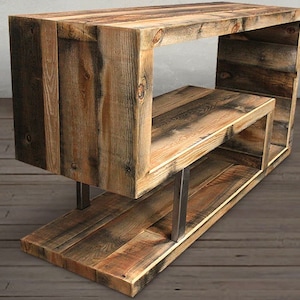 May include: Rustic wooden shelf unit with a unique open design. The shelf is made of reclaimed wood with a natural finish and features metal supports.