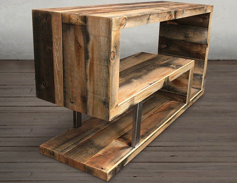 May include: Rustic wooden shelf unit with a unique open design. The shelf is made of reclaimed wood with a natural finish and features metal supports.