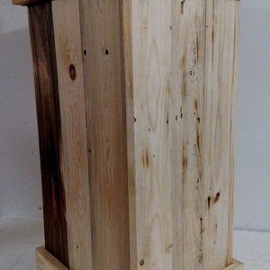 May include: A wooden box with a natural wood finish. The box is made of reclaimed wood and has a rustic look. The box is square and has a simple design.