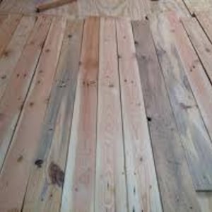 May include: A close-up view of a stack of wooden planks. The planks are light brown in color and have a natural wood grain. They are arranged in a neat and orderly fashion.