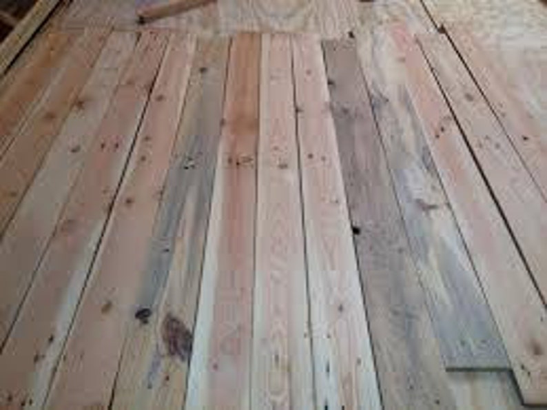 May include: A close-up view of a stack of wooden planks. The planks are light brown in color and have a natural wood grain. They are arranged in a neat and orderly fashion.
