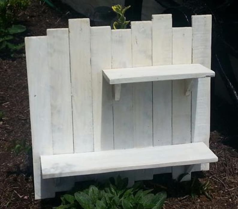 May include: White painted wooden shelf unit with two shelves. The shelves are made from reclaimed wood planks.