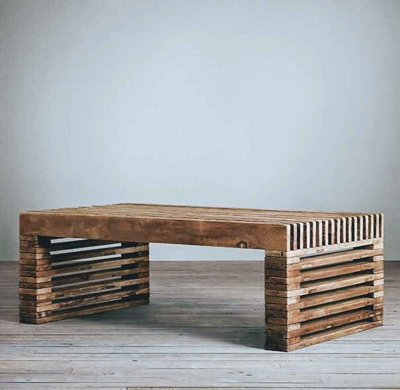 May include: A wooden coffee table with a rectangular top and a slatted design on the sides. The table is made of natural wood and has a rustic look.