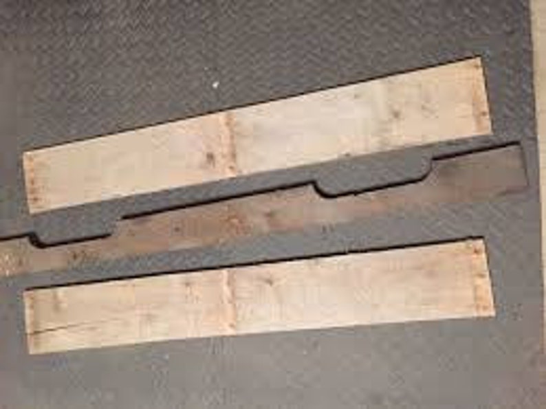 May include: Three pieces of wood, two are light brown and one is dark brown. The dark brown piece has a unique shape with two cutouts.