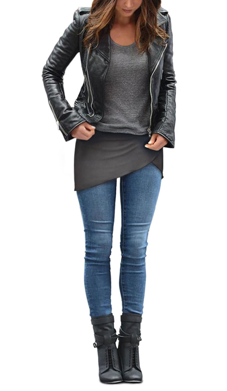 Op de afbeelding: Een vrouw draagt een zwart leren jack, een grijs shirt, een grijze wikkelrok, blauwe jeans en zwarte enkellaarsjes.