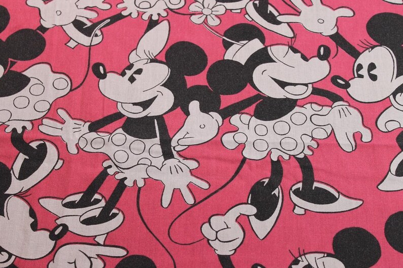 Peut inclure: Tissu rose avec un motif r&eacute;p&eacute;t&eacute; de Minnie Mouse dans diff&eacute;rentes poses. Minnie Mouse est repr&eacute;sent&eacute;e en noir, blanc et rose, portant sa jupe et son n&oelig;ud &agrave; pois embl&eacute;matiques. Le tissu est adapt&eacute; &agrave; divers projets de couture et d'artisanat.