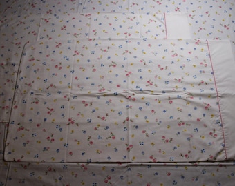 Puede incluir: Un juego de tres fundas de almohada blancas con un pequeño estampado floral en rosa, azul y amarillo.