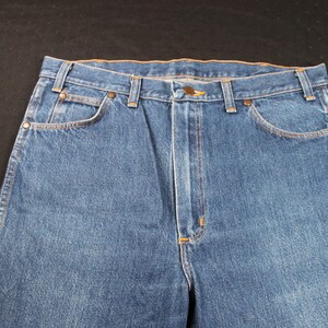 May include: A pair of blue denim jeans with a classic five-pocket style. The jeans have a straight leg and a dark wash.