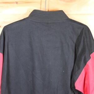 K&ouml;nnte beinhalten: Schwarz-rote Jacke mit langen &Auml;rmeln und Rei&szlig;verschluss.
