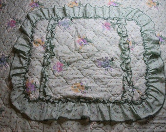 Colcha floral vintage verde e roxa com duas fronhas combinando.