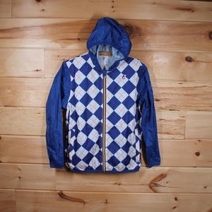 May include: A blue and white argyle patterned hooded jacket with a zipper closure. The jacket has a logo on the left chest.