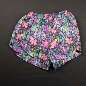 Può includere: Un paio di pantaloncini sportivi con stampa floreale colorata e vita elastica.