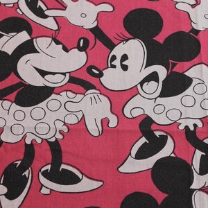 Peut inclure: Tissu rose avec un motif r&eacute;p&eacute;t&eacute; de Minnie Mouse en noir et blanc. Minnie porte une robe blanche &agrave; pois noirs. Le tissu convient &agrave; divers projets de couture.