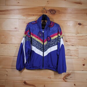 May include: A blue, white, yellow, red, and black patterned jacket with a zipper closure.