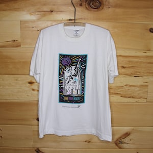 Könnte beinhalten: Weißes T-Shirt mit einem bunten Grafikdesign, das eine Person beim Sport zeigt. Die Grafik lautet "Commit to Get Fit For Your Health" und "The Fitness Institute".