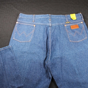 May include: A pair of blue denim jeans with a brown leather patch on the back pocket. The jeans have a classic straight leg style.