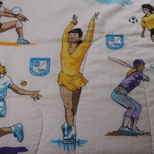 Puede incluir: Tela blanca con ilustraciones de mujeres practicando varios deportes, incluyendo voleibol, tenis, fútbol, patinaje artístico y béisbol. El diseño incluye el texto "ABC Wide World of Sports" en un emblema azul y naranja.