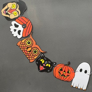 May include: A Halloween banner with orange, black, and white illustrations of a ghost, pumpkin, cat, owl, skull, and a character with a mustache and a hat.