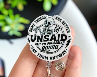 May include: White round badge holder with a black skeleton graphic and the text "Some things are better left unsaid. But I'm probably gonna say them anyway."