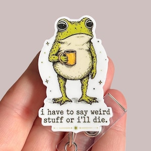 May include: A badge reel featuring a cartoon frog holding a yellow mug. The frog is green and yellow with a white background and the text "i have to say weird stuff or i'll die."
