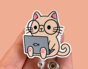 May include: A beige cat wearing glasses and sitting on a laptop with a fish icon. The cat is holding a laptop with its paws. The cat is attached to a white retractable badge holder.