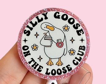 May include: Pink glitter badge holder with a white goose illustration and the text "Silly Goose on the Loose Club".