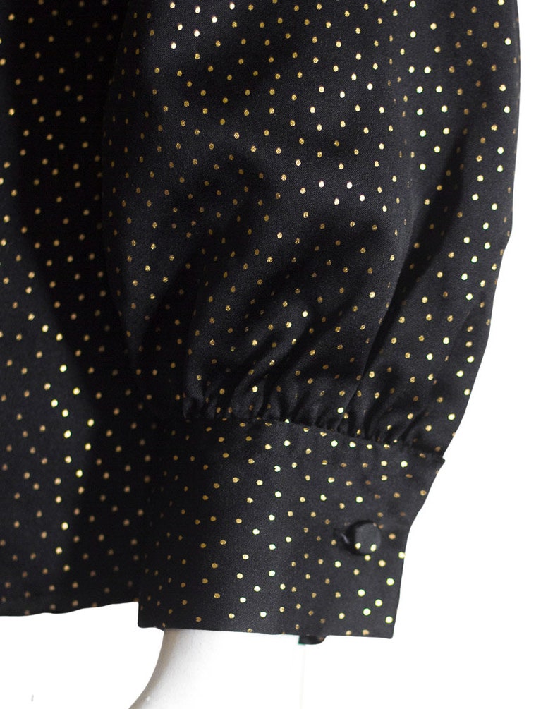 Each sleeve fastens with a fabric covered button