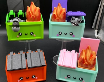 May include: Four miniature trash cans with cute faces. Each can has a different color and features a small fire or animal figurine on top. The cans are arranged on a white surface.