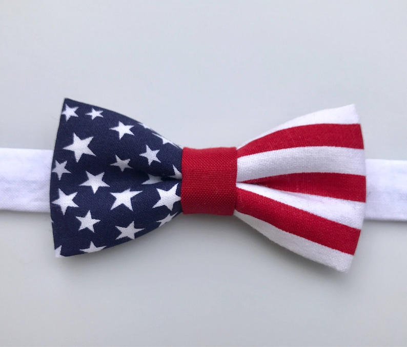 May include: A red, white, and blue bow tie with a star pattern on one side and stripes on the other.