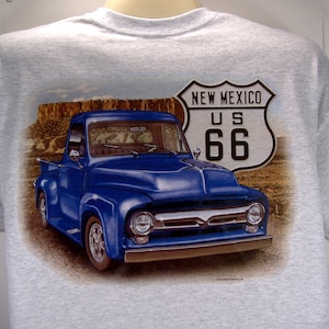 May include: A gray t-shirt with a blue pickup truck and a "New Mexico US 66" road sign printed on the back.