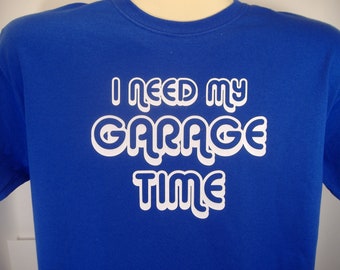 May include: A royal blue t-shirt with white text that reads "I need my garage time".