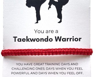 May include: A white card with a red bracelet and the words "You are a Taekwondo Warrior." The card features black silhouettes of two people performing Taekwondo. The text encourages courage and self-discipline.