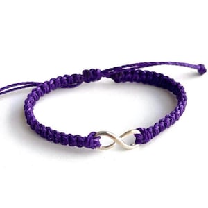 May include: A purple braided friendship bracelet with a silver infinity charm.