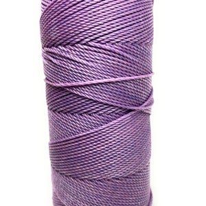 May include: A spool of purple yarn, wound tightly and ready for crafting projects.