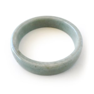 Könnte beinhalten: Ein hellgrünes Jade-Armband. Das Armband ist glatt und poliert.