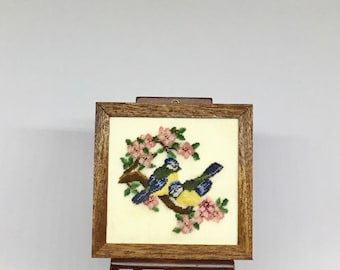 Miniature picture frame for dollhouse with antique design embroidered in petit point on silk gauze.