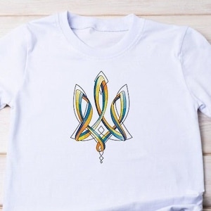 Könnte beinhalten: Weißes T-Shirt mit einem farbenfrohen, stilisierten Dreizack-Design in Gelb, Blau und Orange, umrandet von Schwarz. Das T-Shirt wird mit Sonnenbrille und Jeansshorts präsentiert. Der Dreizack ist ein Symbol der Ukraine.