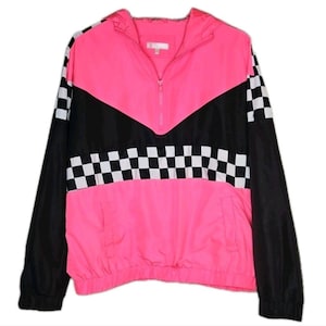 Può includere: Giacca a vento rosa e nera con motivo a scacchi. La giacca presenta una chiusura a mezza zip, un cappuccio e maniche nere. Il pannello frontale è rosa acceso, con un design a chevron nero sul petto e dettagli a scacchi.