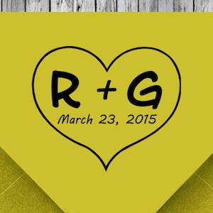 May include: A yellow envelope with a black heart drawn on it. The heart has the letters R + G inside and the text "March 23, 2015" below.