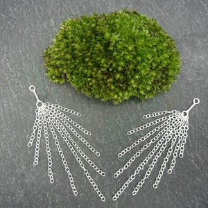 May include: A pair of silver dangle earrings with multiple chains hanging from a small loop. The chains are arranged in a fan shape.