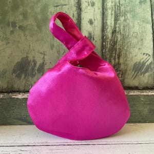 Bolso de mano reversible con nudo japonés en satén rosa fucsia