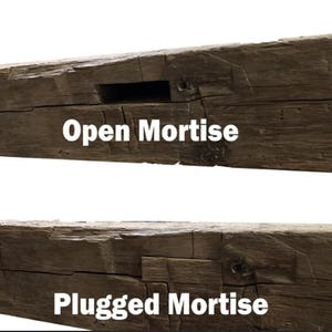 May include: Two sections of weathered, dark brown wooden beams. The top beam has an open mortise, and the text "Open Mortise" is displayed. The bottom beam has a plugged mortise, with the text "Plugged Mortise".