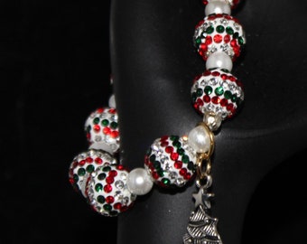 Pulsera elástica con cuentas blancas con cristales verdes, rojos y transparentes incrustados y dije de árbol de Navidad