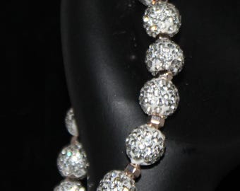 Pulsera elástica con cuentas blancas y cristales plateados incrustados